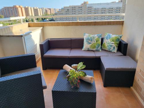 a balcony with a couch and a table and chairs at JARDINES DEL MAR I APTO 298 OROPESA DEL MAR MARINA DOR in Oropesa del Mar