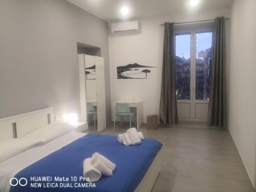 Un dormitorio con una cama azul con toallas. en Eleonora's Home en Nápoles