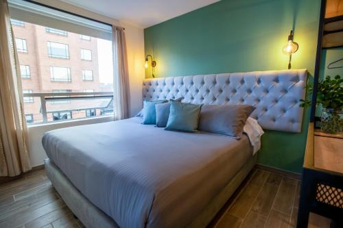 a bedroom with a large bed with a large window at 103 Wonderful House in Bogotá
