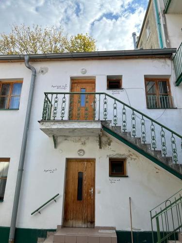 a white building with a balcony and a staircase at Byt v Kačení ulici in Olomouc