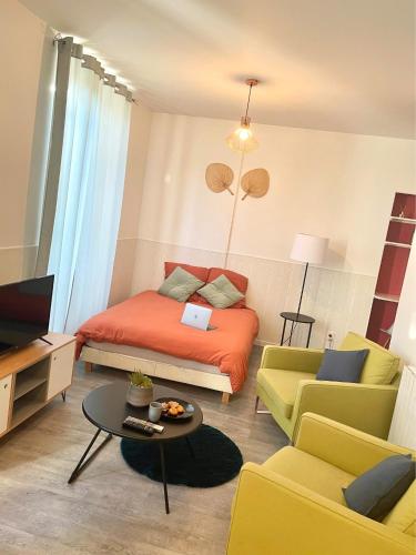 um quarto com uma cama, um sofá e uma mesa em Studio Cosy en Plein Centre em Corbeil-Essonnes