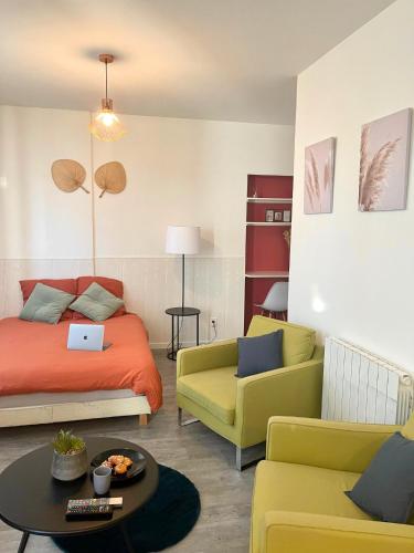 a room with a bed and a couch and a table at Studio Cosy en Plein Centre in Corbeil-Essonnes