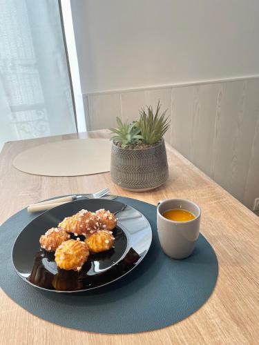 um prato de comida e uma chávena de chá numa mesa em Studio Cosy en Plein Centre em Corbeil-Essonnes