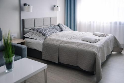 a bedroom with a large bed and a table at Apartament Turysta in Licheń Stary
