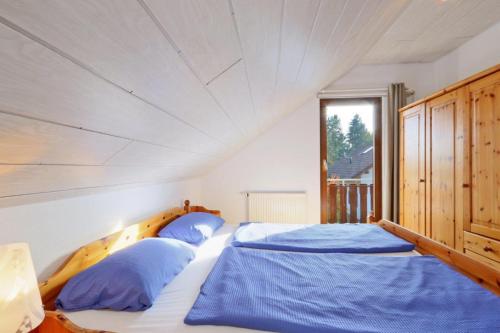a bedroom with a large bed with blue pillows at Seepark Kirchheim Ferienhaus bei Anne mit Sauna in Kirchheim