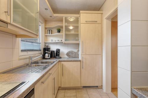 a kitchen with wooden cabinets and a sink at Seepark Kirchheim Ferienhaus bei Anne mit Sauna in Kirchheim