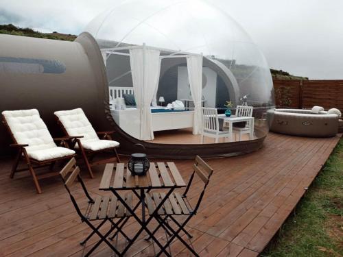 a igloo house with a patio and a table and chairs at Hotel burbuja Finca Esferas in Santa Cruz de Tenerife