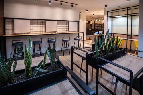 a bar with plants and bar stools at 103 Wonderful House in Bogotá