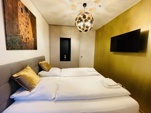 a bed with white sheets and a television in a room at Royal Swan Skyline, Wien in Vienna