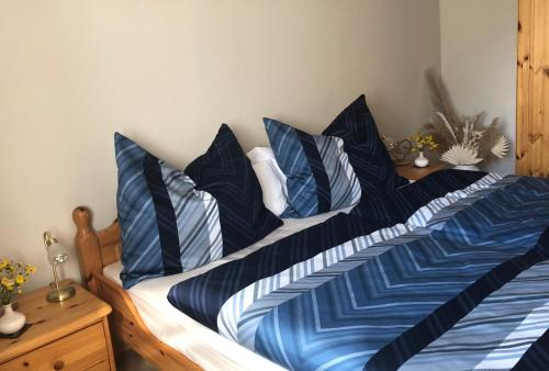 a bed with blue and white sheets and pillows at Haus Seebach in Mallnitz