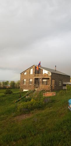 a brick house in a field with a kite on it at Guest House AREVIK in Artsvakar