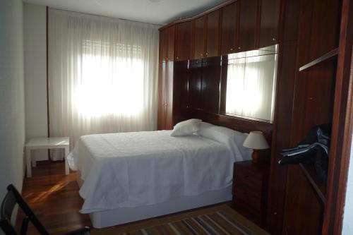 een slaapkamer met een wit bed en een raam bij APARTAMENTO LOS ABEDULES in Santander
