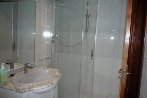 uma casa de banho com um chuveiro e um lavatório. em APARTAMENTO LOS ABEDULES em Santander