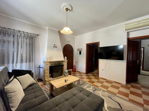 a living room with a couch and a fireplace at Serenita Villa II in Zakynthos Town
