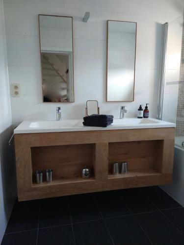 a bathroom with a sink and two mirrors at murkerka in Damme