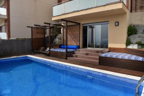 a house with a swimming pool and a house at Villa Miramar Panoramic Views in Santa Susanna