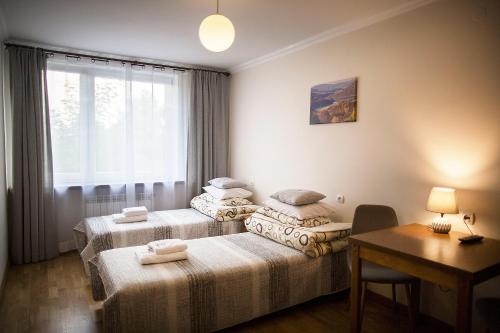 two beds in a room with a table and a desk at DW Halicz in Solina