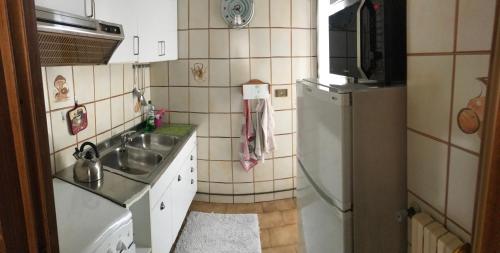 a small kitchen with a sink and a refrigerator at Appartamento per brevi periodi "Michélmabel" in Bergamo