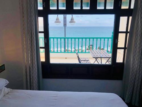 a bedroom with a view of the ocean from a window at Ocean’s Eleven Punta Mujeres in Punta de Mujeres