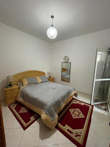 a bedroom with a bed and a chandelier at Appartement Familial Al Hoceima WiFi in Al Hoceïma