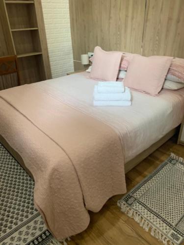 拉臘的住宿－Larache city，一张带粉红色枕头的床和毛巾