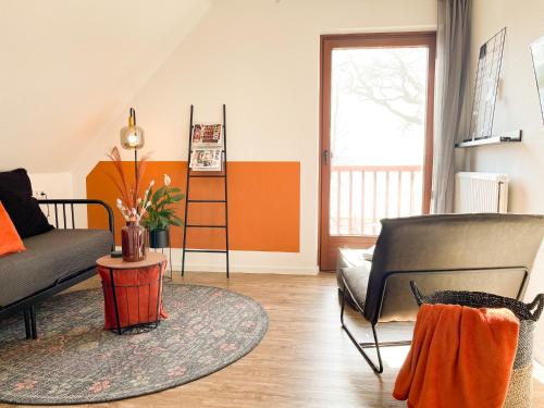 uma sala de estar com um sofá e uma cadeira em Ferienhof Bannick em Bistensee