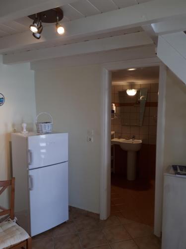 eine Küche mit einem weißen Kühlschrank und einer Spüle in der Unterkunft Roula's Suites in Ándros