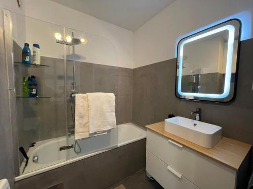 a bathroom with a sink and a shower and a mirror at Spacious 3bd top floor flat close to lake (103m²) in Klagenfurt