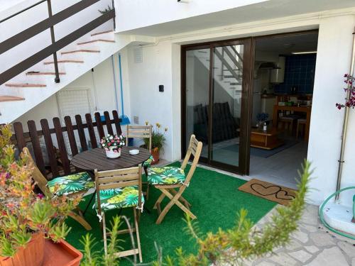 a small patio with a wooden table and chairs at Casinha Alice in Nazaré