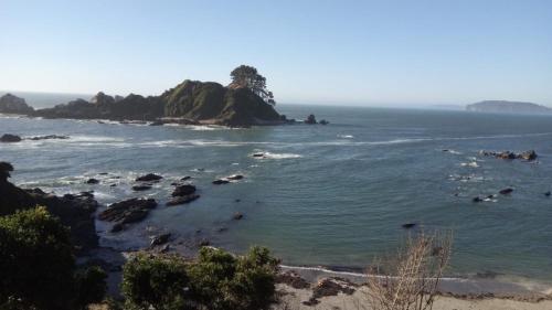 a view of the ocean with rocks in the water at DepartamentoVista Queule in Toltén