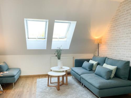 a living room with a blue couch and a table at Ferienhof Bannick in Bistensee