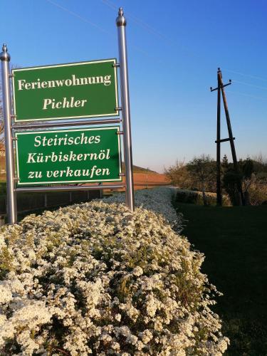 a green sign sitting on top of a pile of flowers at Ferienwohnung Pichler in Leibnitz
