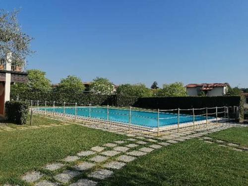 einen Zaun um einen Pool im Hof in der Unterkunft Casa degli Ulivi in Padenghe sul Garda