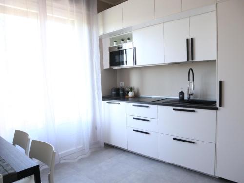 een witte keuken met een wastafel en een magnetron bij Le Case di Sonia TRE GEMME RUBINO Fucecchio in Fucecchio