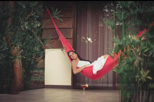 a woman laying in a hammock in a room at Hotel Colinas del Miravalles in Hacienda Guayabo
