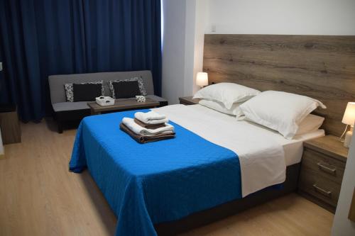 a bedroom with a large bed with a blue blanket at Sea Krystel 603 in Larnaca