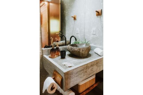 a bathroom with a marble sink and a mirror at Vila do Porto, Praia do Patacho - Bangalô Toque in Pôrto de Pedras