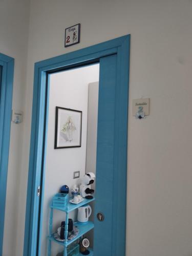 a blue door with a mirror in a room at Sisinedda in Siniscola