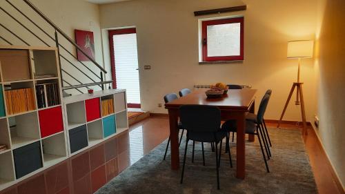 a dining room with a table and chairs and a staircase at Villas do Laboreiro - Casa 8 in Castro Laboreiro