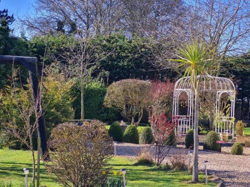 un giardino con gazebo bianco e palma di Green Haven a Friskney