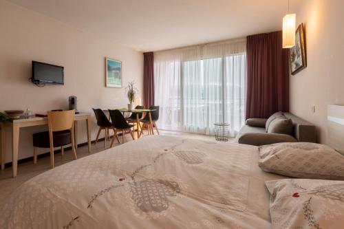 una habitación de hotel con una cama grande y una mesa en Family Saint Vincent 4 pers gare lourdes wifi en Lourdes