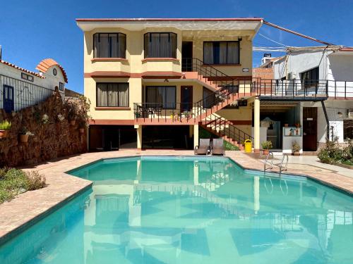 a house with a swimming pool in front of a house at Hotel Mitru in Tupiza