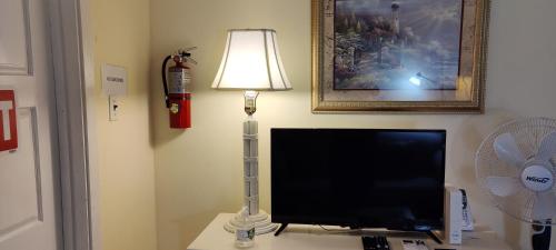 a lamp sitting on a desk next to a television at Beryls at Seawind on the Bay , Montego Bay , Jamaica in Montego Bay