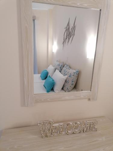 a mirror on a wall with pillows on a bed at Akrogiali in Skala