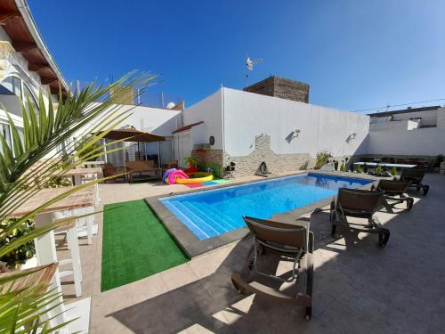 un patio trasero con piscina y sillas junto a un edificio en TENERIFE LITTLE VILLAGE S, en San Isidro