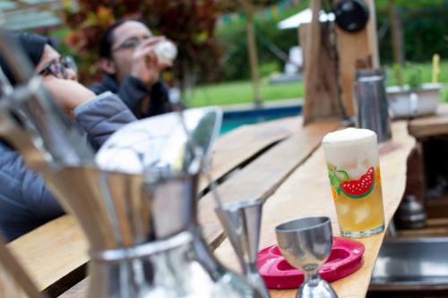 a man sitting at a table with a glass of beer at Mama Tungu hostel in Baños