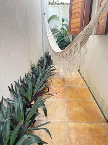 a swinging hammock in a room with plants at Villa Mar Residence in Jericoacoara