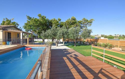 a swimming pool with a wooden walkway next to a house at Villetta Gaia in Marina di Ragusa