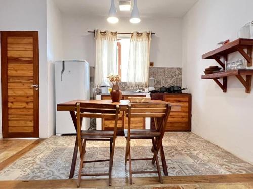 a kitchen with a table and chairs and a refrigerator at Villa Mar Residence in Jericoacoara