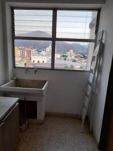 Baño con lavabo y escalera junto a una ventana en Lo de Marta en Salta
